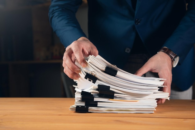 Bedrijfsconcept man werknemer met stapel documenten