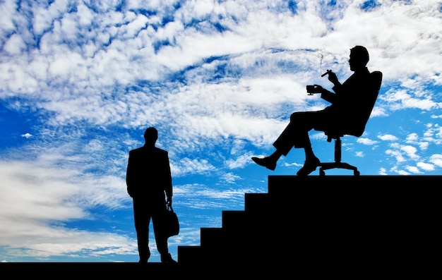 Bedrijfsconcept. Silhouet van baas en werknemer op een achtergrond van de trap en de prachtige lucht