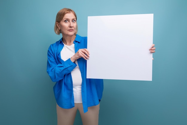 Bedrijfsconcept van middelbare leeftijd Vrouw van middelbare leeftijd met een poster voor notities met een mocap op een blauw