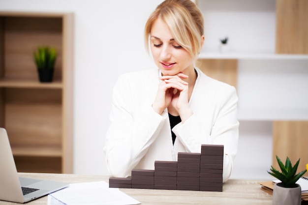 Bedrijfsconcept, vrouw bouwt een bedrijfsontwikkelingsstrategie uit houten kubus