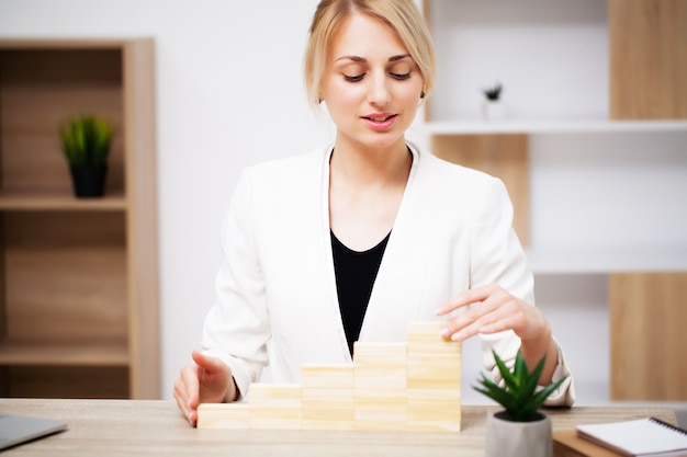 Bedrijfsconcept, vrouw bouwt een bedrijfsontwikkelingsstrategie uit houten kubus