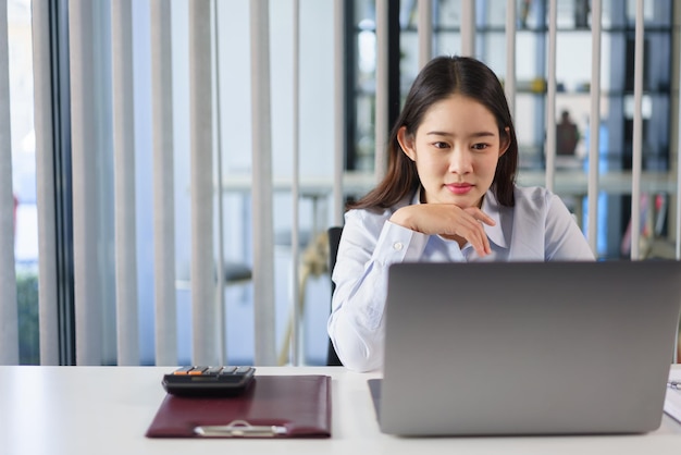 Bedrijfsconcept Zakenvrouw nadenkend over nieuw project tijdens het lezen van marketinggegevens op laptop