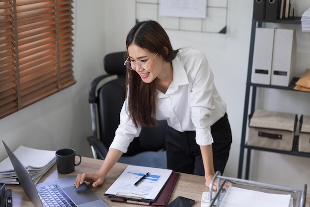 Bedrijfsconcept Zakenvrouw typt om gegevens te zoeken en een bedrijfsrapport op laptop te lezen