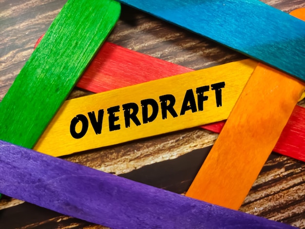 Foto bedrijfsconcepttekst overdraft schrijven op gekleurde ijsstokjes op houten achtergrond