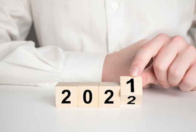 Bedrijfsgroeiconcept in 2022 voor businessplan en strategie Hand flips houten kubussen 2022 en groeitrend op mooie achtergrond en kopieer ruimte Banner voor het nieuwe actieplan jaarplan