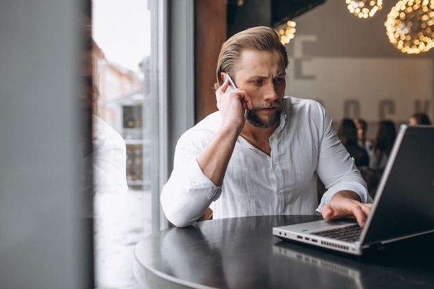 Bedrijfsmens die aan computer in een koffie werken