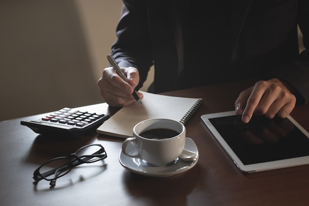 Bedrijfsmens die aan digitale tablet op houten lijst werken