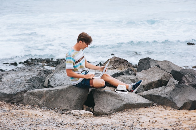 Bedrijfsmens die aan het strand met laptop werken