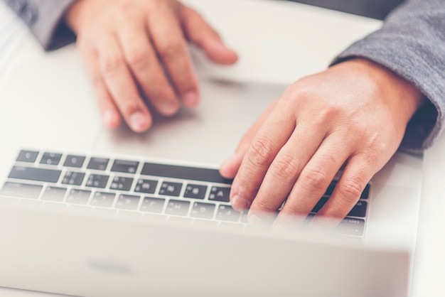 Bedrijfsmens die op kantoor met laptop en documenten aan zijn bureau werken