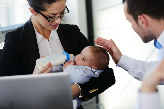 Bedrijfsmensen die baby in bureau behandelen