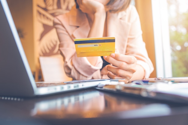 Bedrijfsmensen die creditcards houden en laptops gebruiken die online winkelen.