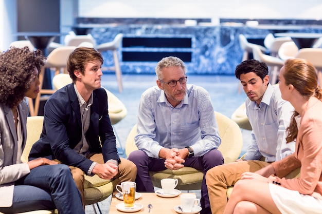 Bedrijfsmensen die een bespreking in cafetaria hebben