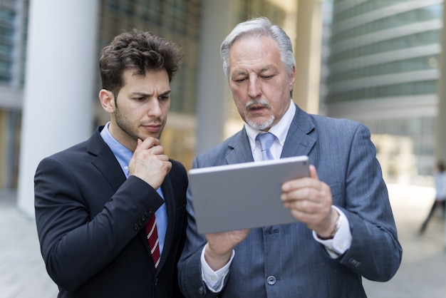 Bedrijfsmensen die een tablet in openlucht gebruiken