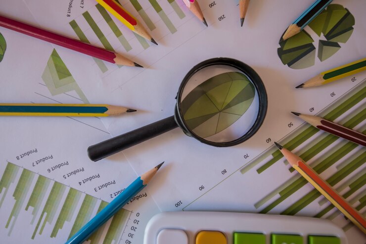 Foto bedrijfstoebehoren (notitieboekje, meer magnifier, calculator, planchette, tablet, vulpen, notitieboekje, glazen) en grafiek, lijsten, grafieken op een houten bureau. soft focus