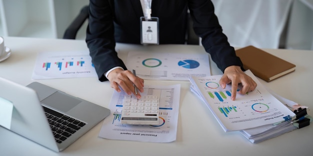 Bedrijfsvrouw boekhouder met behulp van rekenmachine en laptop voor het opslaan van financiële gegevens in kantoorruimte Bedrijfsbedrijfsbelasting boekhoudconcept.