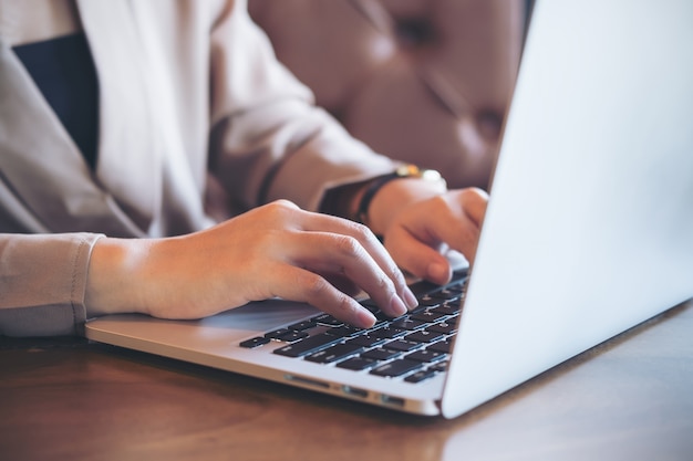 Bedrijfsvrouw die computerlaptop met behulp van