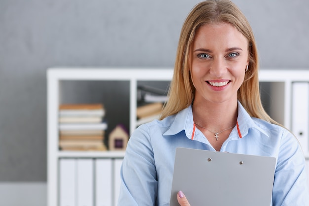 Bedrijfsvrouw die een schrijftablet in het bureau houden