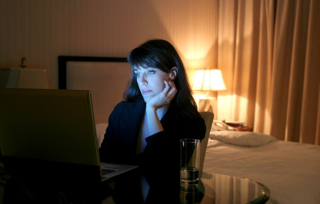 Bedrijfsvrouw die laptop in een hotelruimte met behulp van