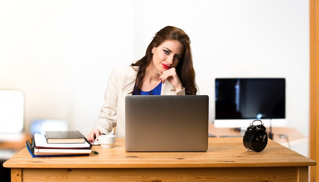 Bedrijfsvrouw die met haar laptop in het bureau werken