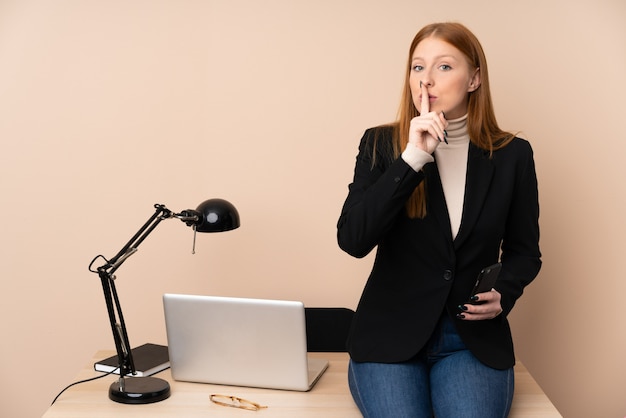 Bedrijfsvrouw in een bureau dat stiltegebaar doet