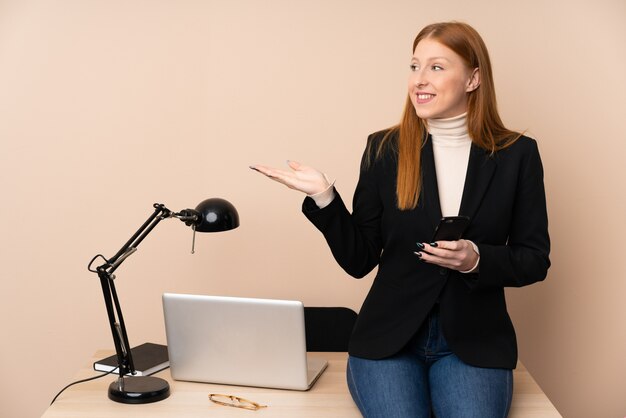 Bedrijfsvrouw in een bureau die handen uitbreiden aan de kant voor het uitnodigen om te komen