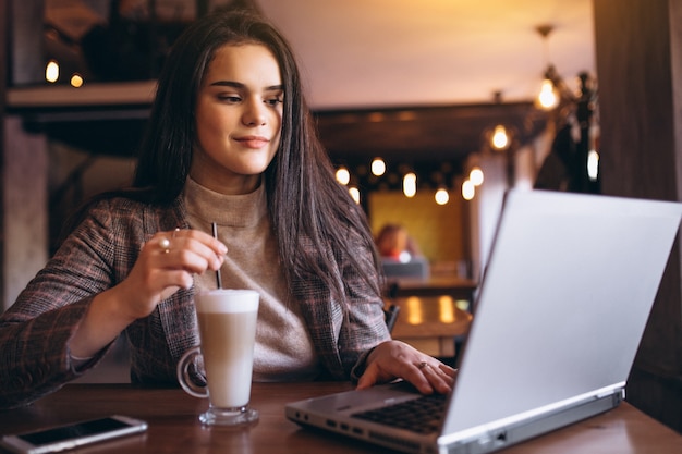 Bedrijfsvrouw met laptop en koffie in een koffie
