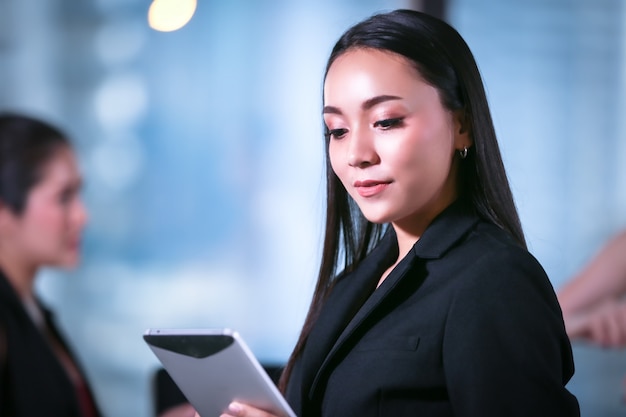 bedrijfsvrouwen die tablet houden zich bevindt in bureau