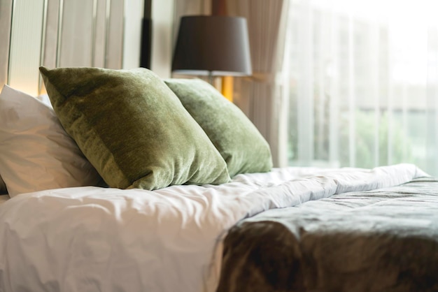 寝室のインテリアデザインクローズアップホームインテリアコンセプト柔らかい枕は、白いカーテンの背景を持つ寝室のキングサイズの白い毛布マットレスに配置ホームスイートホームインテリアのアイデア