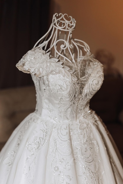 Bedroom interior with wedding dress prepared for the ceremony A beautiful lush wedding dress on a mannequin in a hotel room