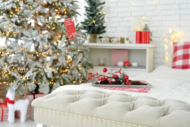 The bedroom is decorated with Christmas decor Focus on the bedside bench