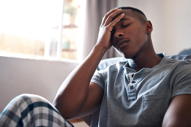 Bedroom tired or black man with stress for insomnia depression or sad after break up at home Male person trauma or frustrated with headache for relationship crisis anxiety or heartbreak in house