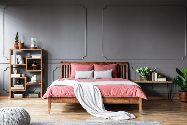 A bedroom with a bed and a shelf with books on it.