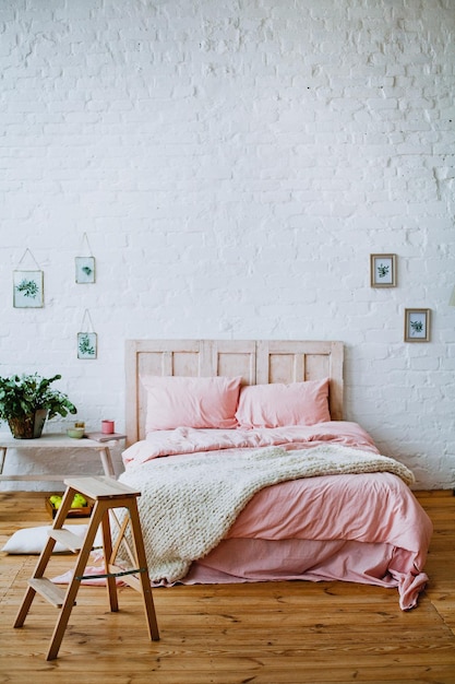 A bedroom with a wooden bed and a wooden table with a plant on it