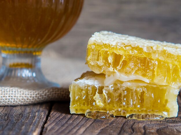 Bee honeycomb with honey close-up on an old wooden table