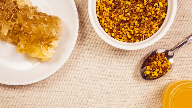 Bee pollen; honeycomb; honey arranged in jute background