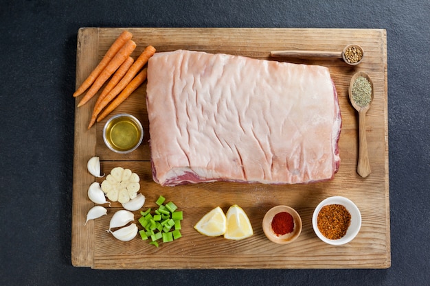 Beef brisket and ingredients on wooden board