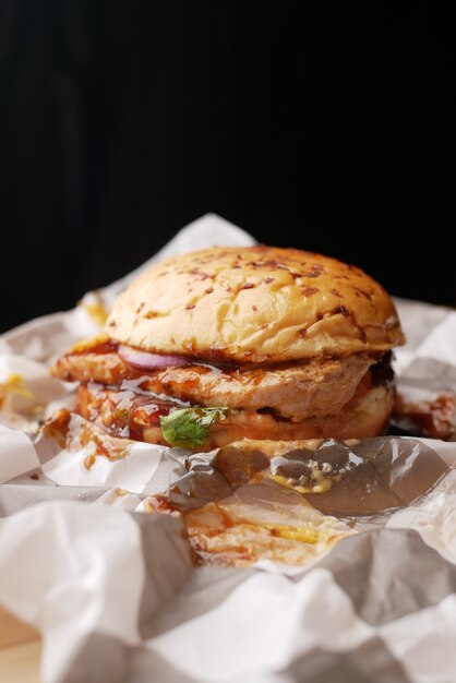 beef burger on a chopping board against black background