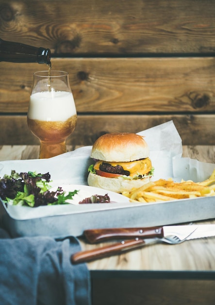 Insalata di patatine fritte con hamburger di manzo e bicchiere di birra