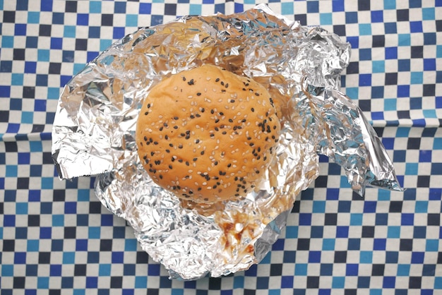 Beef burger and french fries in a takeaway paper box on table