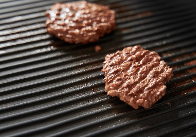 Beef burger patties on griddle pan cooking copy space for design mockup