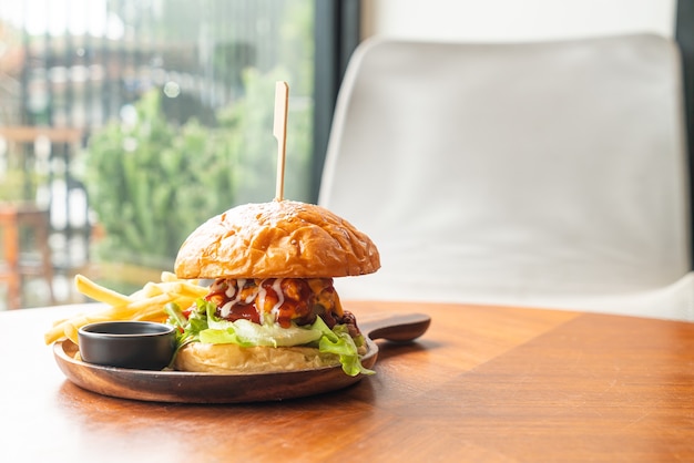 beef burger with cheese and sauce on wood plate