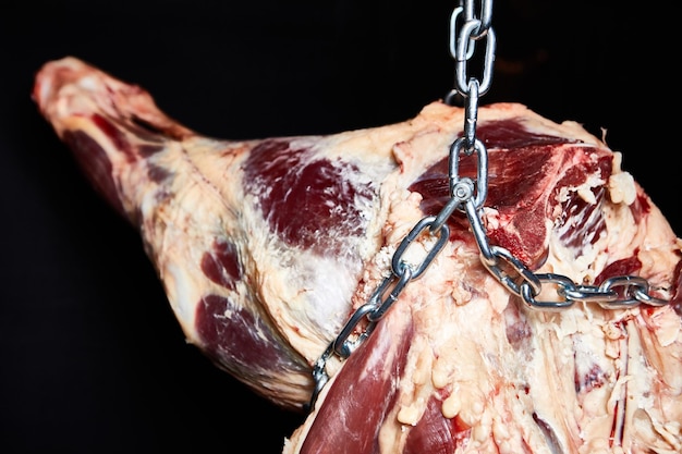 Photo beef carcass hanging on a black background