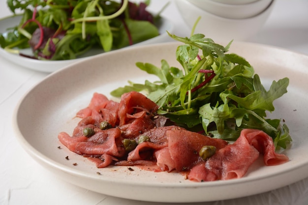 Beef Carpaccio  with parmesan, capers and arugula. With olive oil and soy sauce