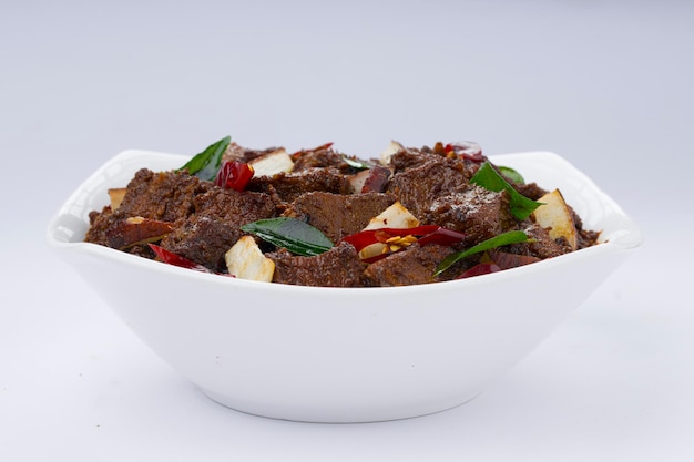 Beef gebraden masala of curry zelfgemaakte recept gerangschikt in witte kom met witte achtergrond