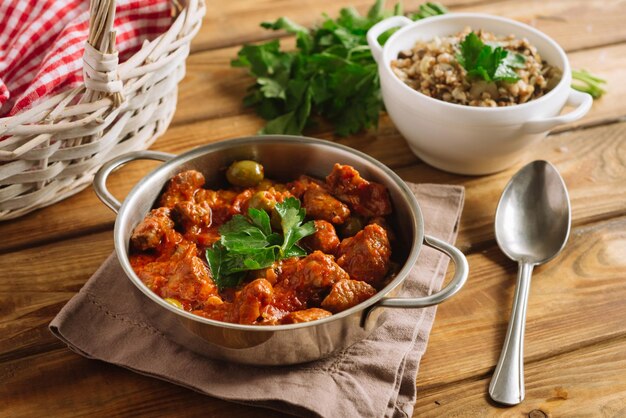 Beef goulash in tomato sauce with olives and boiled buckwheat