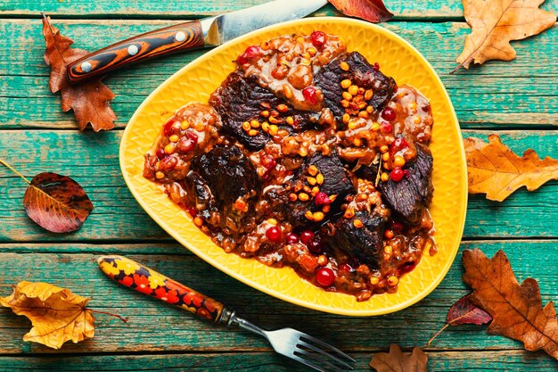 Beef grilled in autumn berries. Meat with cranberries and sea buckthorn.