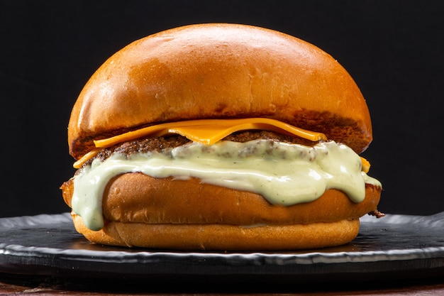 Фото Говяжий гамбургер с расплавленным сыром чеддер и майонезом на гамбургерной булочке