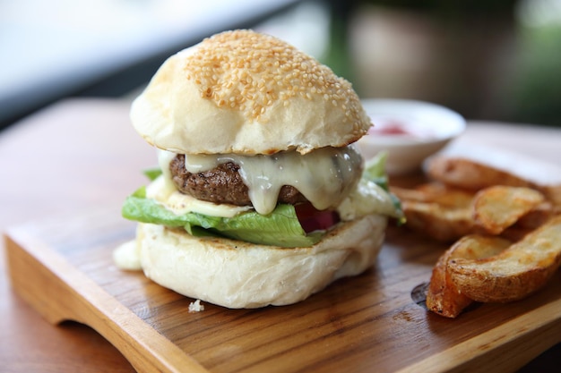 チーズと木の背景に火のビーフハンバーガー