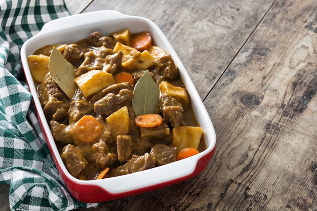 Beef meat stewed with potatoes, carrots and spices in ceramic pot