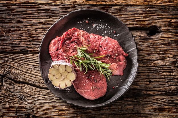 Beef meeat Rib-Eye steak met rozemarijnzout en peper op zwarte plaat.